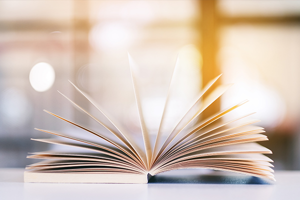 Ein aufgeschlagenes Buch auf einem Tisch.